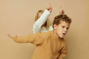 pequeño chico y niña gesticular con su manos juntos estilo de vida inalterado foto