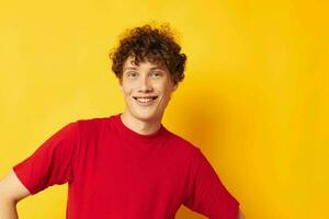 portrait of a young curly man red t shirt fun posing casual wear isolated background unaltered photo