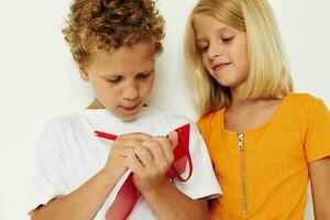 Boy and girl fun in colorful t-shirts with a notepad isolated background unaltered photo