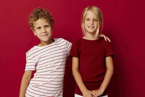 two joyful children emotions stand side by side in everyday clothes on colored background photo