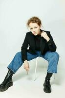 beautiful woman sitting on a chair in a black jacket fashion posing Lifestyle unaltered photo