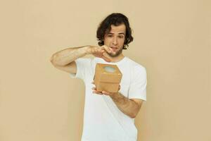 alegre hombre en un blanco camiseta con un regalo caja foto