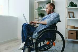 Man wheelchair freelancer working at laptop at home smile, working online, social networks and startup, copy space, integration into society, health concept man with disabilities, real person close-up photo