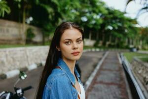 Portrait of a woman brunette smile with teeth walking outside against a backdrop of palm trees in the tropics, summer vacations and outdoor recreation, the carefree lifestyle of a freelance student. photo