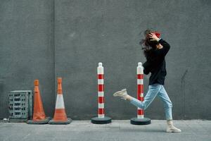 Fashion woman running down the street in front of the city tourist in stylish clothes with red lips and red beret, travel, cinematic color, retro vintage style, late to work. photo