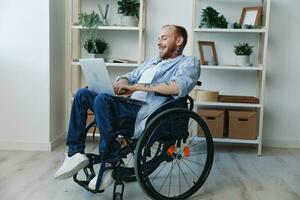 Man in wheelchair freelancer working at laptop at home smile, working online, social networks and startup, copy space, social integration, health concept man with disabilities, real person photo