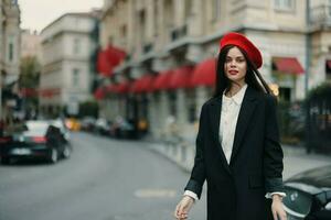 Fashion woman portrait standing on the street in front of the city in stylish clothes with red lips and red beret, travel, cinematic color, retro vintage style, urban fashion lifestyle. photo