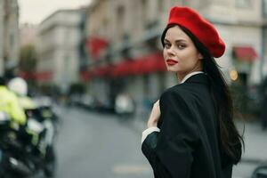 Fashion woman portrait beauty standing on the street in front of the city in stylish clothes with red lips and red beret, travel, cinematic color, retro vintage style, urban fashion lifestyle. photo