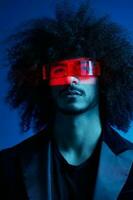 Fashion portrait of a man with curly hair on a blue background wearing red sunglasses, multinational, colored light, trendy, modern concept. photo