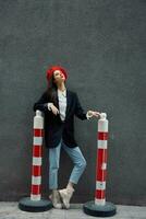 Fashion woman standing on the street in front of the city and road works tourist in stylish clothes with red lips and red beret, travel, cinematic color, retro vintage style. photo