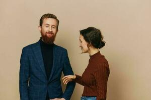 Man and woman couple in a relationship smile and interaction on a beige background in a real relationship between people photo