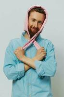 gracioso hombre en un rosado sombrero retrato en un ligero gris antecedentes. sonrisa y positivo emociones foto