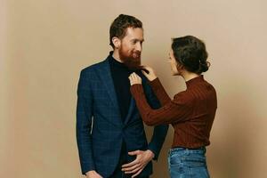 Man and woman couple in a relationship smile and interaction on a beige background in a real relationship between people photo