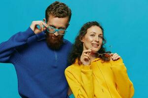 A woman and a man fun couple cranking and showing signs with their hands smiling cheerfully, on a blue background, The concept of a real relationship in a family. photo