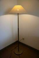 Interior with floor lamp and glow bulb in the dark at night, one lamp in the corner against a floor lamp wall. photo