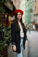 mujer sonrisa Moda modelo camina en el calle en el ciudad centrar entre el multitud en un chaqueta y rojo boina y vaqueros, cinematográfico francés Moda estilo ropa, viaje a Estanbul primavera foto