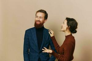 Man and woman couple in a relationship smile and interaction on a beige background in a real relationship between people photo