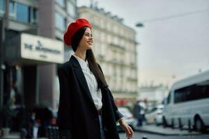 un sonrisa mujer con negocio dientes camina en el ciudad en contra el fondo de oficina edificios, elegante de moda ropa y constituir, primavera caminar, viajar. foto