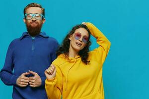 A woman and a man fun couple cranking and showing signs with their hands smiling cheerfully, on a blue background, The concept of a real relationship in a family. photo
