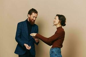 Man and woman couple in a relationship smile and interaction on a beige background in a real relationship between people photo