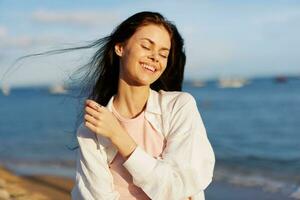 A woman with her eyes closed in the sun on a horse on the ocean smile, flying hair, tanned skin, rest, the concept of skin care in summer and spring. photo