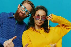 A woman and a man fun couple cranking and showing signs with their hands smiling cheerfully, on a blue background, The concept of a real relationship in a family. photo