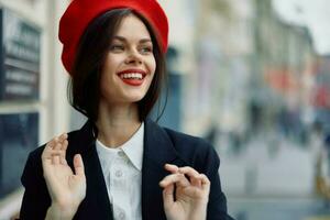 Moda mujer sonrisa primavera caminando en el ciudad en elegante ropa con rojo labios y rojo boina, viajar, cinematográfico color, retro Clásico estilo, urbano Moda estilo de vida. foto