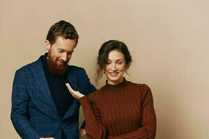 Man and woman couple in a relationship smile and interaction on a beige background in a real relationship between people photo