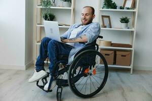 Man in wheelchair freelancer working at laptop at home smile, working online, social networks and startup, copy space, social integration, health concept man with disabilities, real person photo