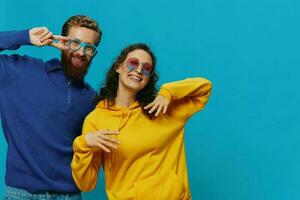 A woman and a man fun couple cranking and showing signs with their hands smiling cheerfully, on a blue background, The concept of a real relationship in a family. photo