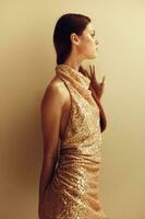 Young slender woman in gold sequined dress with open back, disco party style Christmas look photo