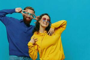 A woman and a man fun couple cranking and showing signs with their hands smiling cheerfully, on a blue background, The concept of a real relationship in a family. photo