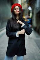 Fashion woman portrait walking tourist in stylish clothes with red lips walking down narrow city street, travel, cinematic color, retro vintage style, dramatic look without smile sadness. photo