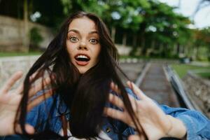 Portrait of a woman brunette smile with teeth walking outside against a backdrop of palm trees in the tropics, summer vacations and outdoor recreation, the carefree lifestyle of a freelance student. photo