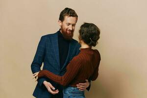 Man and woman couple in a relationship smile and interaction on a beige background in a real relationship between people photo