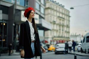 un sonrisa mujer con negocio dientes camina en el ciudad en contra el fondo de oficina edificios, elegante de moda ropa y constituir, primavera caminar, viajar. foto