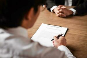 Image of employer or recruiter holding reading a resume during about colloquy his profile of candidate. photo