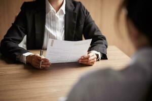 Image of employer or recruiter holding reading a resume during about colloquy his profile of candidate. photo