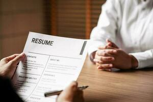 Image of employer or recruiter holding reading a resume during about colloquy his profile of candidate. photo