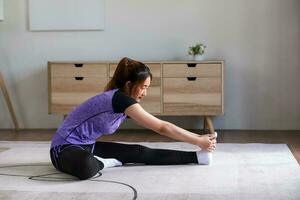 Asian woman in sports wear doing workout at home. home exercise concept. photo