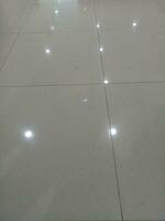 Photo of a gray tiled floor with white light shadows