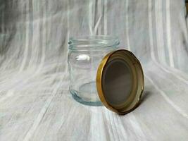 An empty glass jar with a golden lid photo