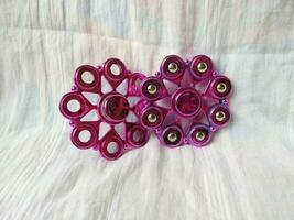 A toy called spinner is purple in color with a unique shape photo