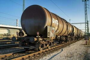 International train transportation. Cargo freight train wagon at Kelenfold train station. Oil transport. photo