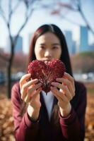 Photo of flower red Heart in girl hand focus of heart for mother love. Valentines day concept. generative ai