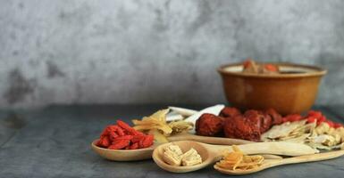 Close up spoon of goji berry and other dried herbs for make healthy soup photo