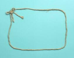 Top view of rope frame tie as bow at the corner on light blue background photo