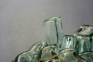 Closeup and crop of up side down and bottom of flat glass bottle on blurred gray background. photo