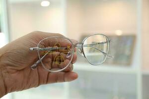 Hand holding eyeglass progressive lens in optical store photo