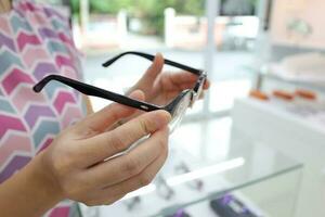 Hand holding glasses on blur background photo